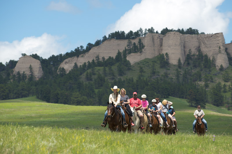 Nine horseback riders on the trails of Nebraska